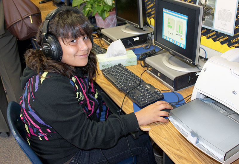 Female student working at computer with headphones on