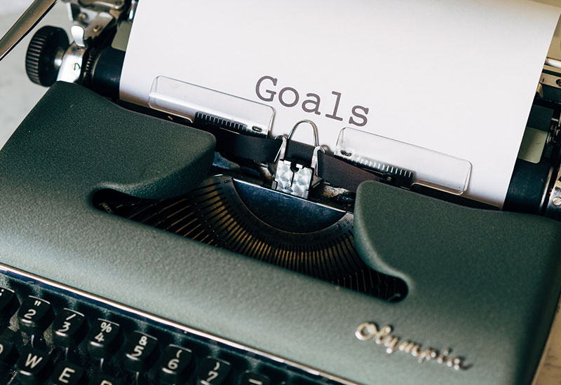 Typewriter with goals written on paper