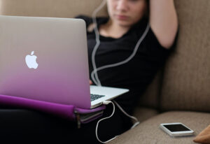 Student with computer and mobile phone