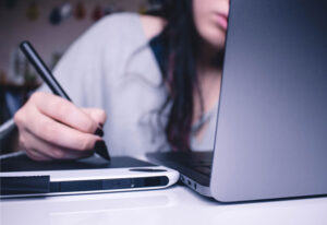 Woman writing notes on tablet