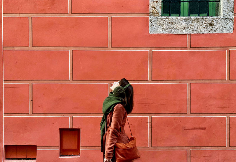 Woman dressed warmly looking up to the sky