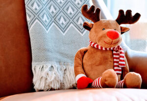 Stuffed animal of a reindeer seated on a coach