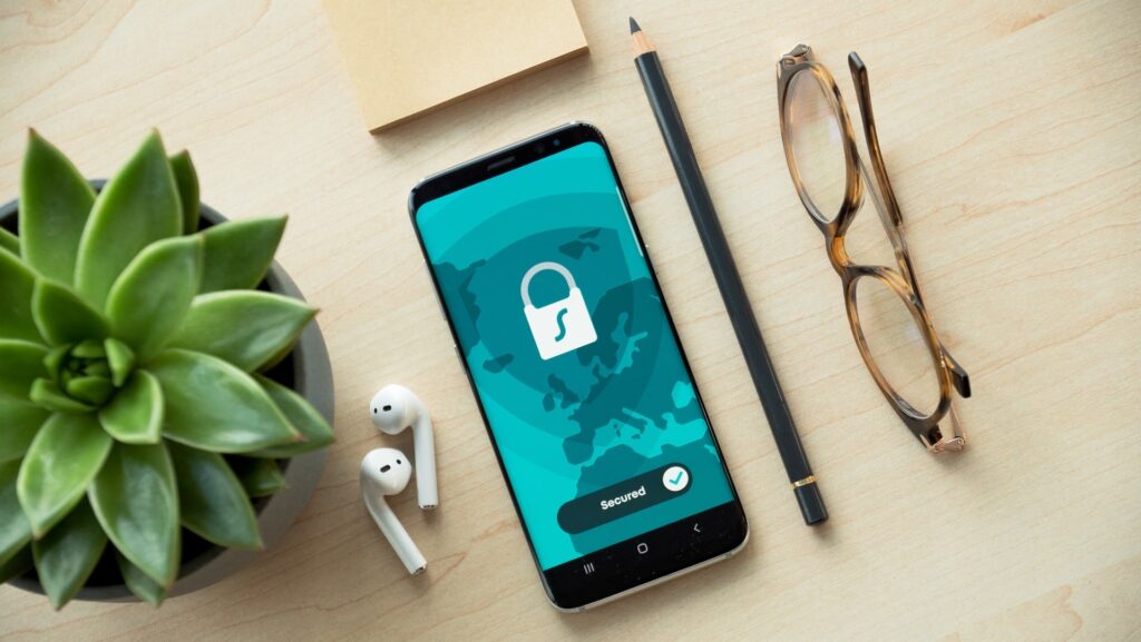 Image of mobile phone, pencil, glasses, AirPods, and plant