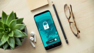 Image of mobile phone, pencil, glasses, AirPods, and plant