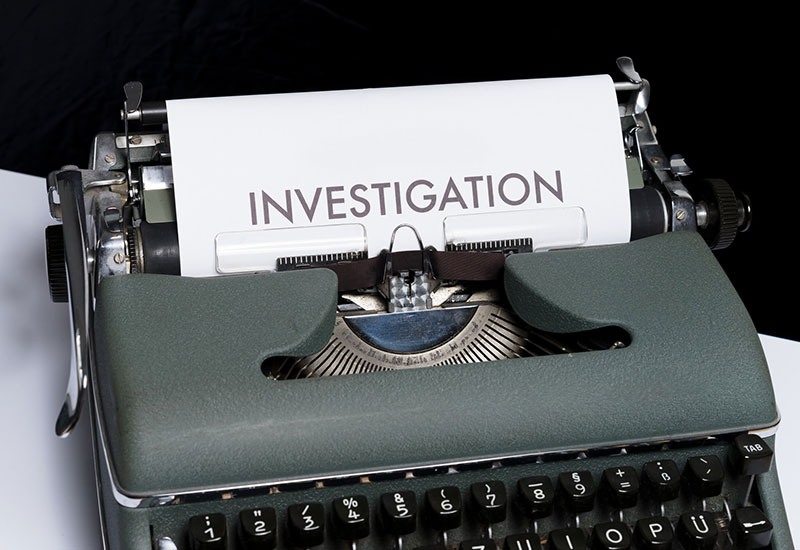 Manual typewriter with piece of paper loaded that says Investigation