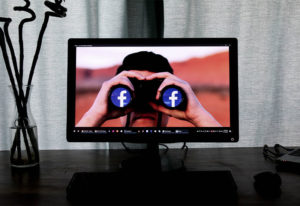 Computer screen with man looking out of binoculars