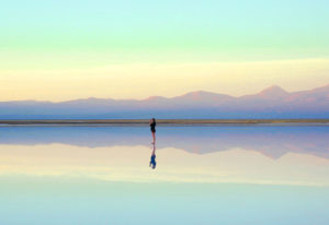 Reflection of woman in a lake at sunset