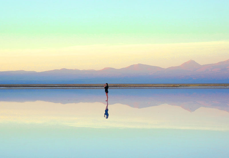 Reflection of woman in a lake at sunset