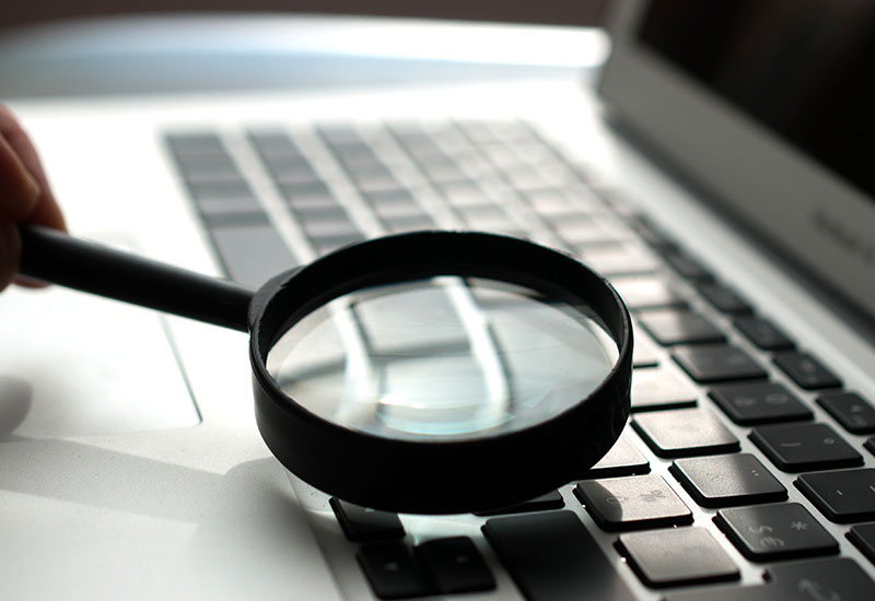 Magnifying glass on laptop keyboard