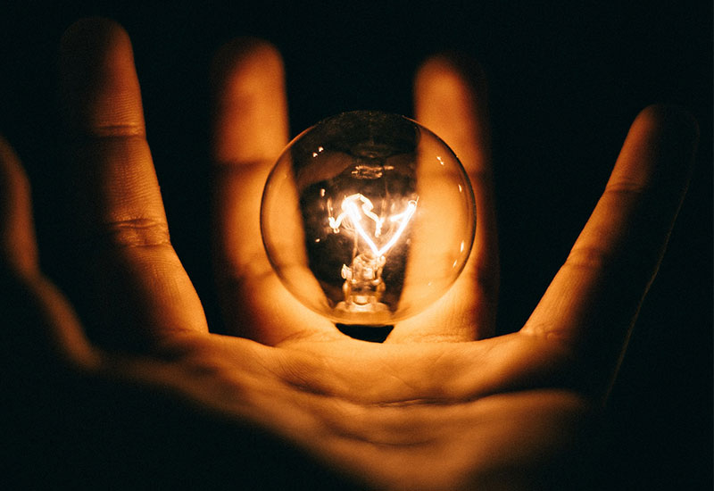 Hand holding a lightbulb