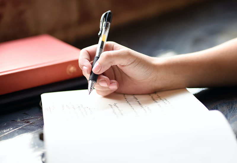 Student's hand writing in notebook